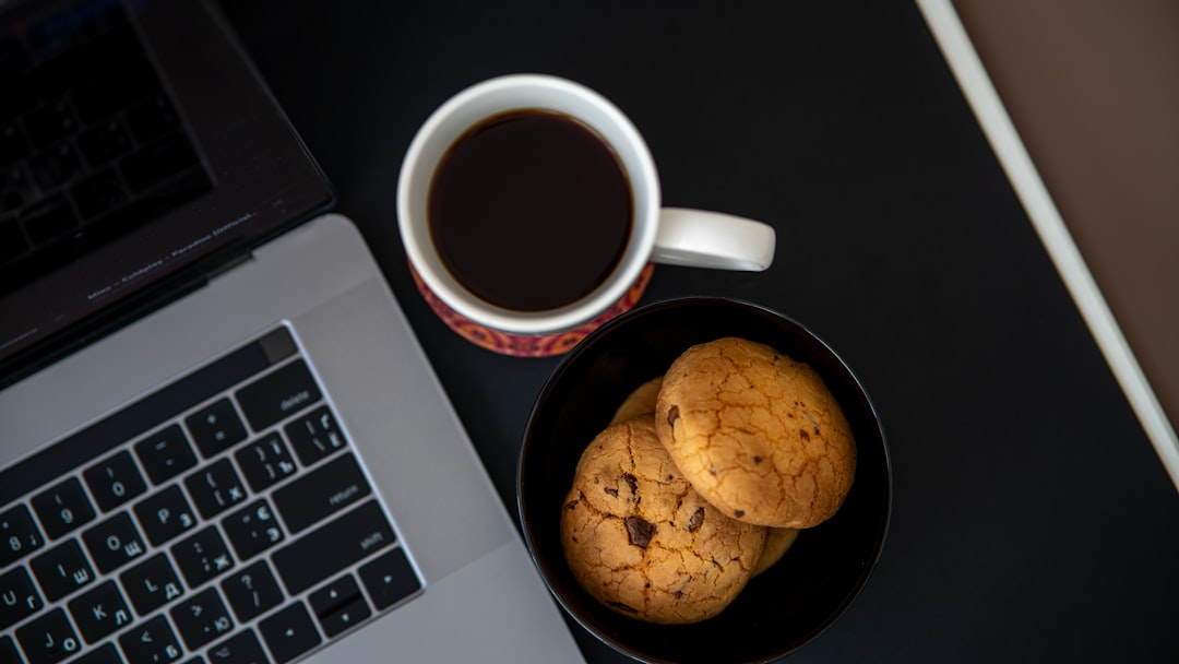 A cup of coffee and some cookies on a desk