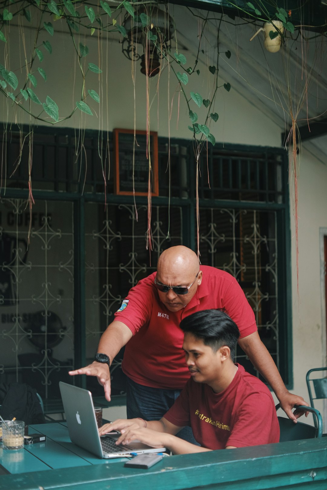 two men looking at a laptop on a table