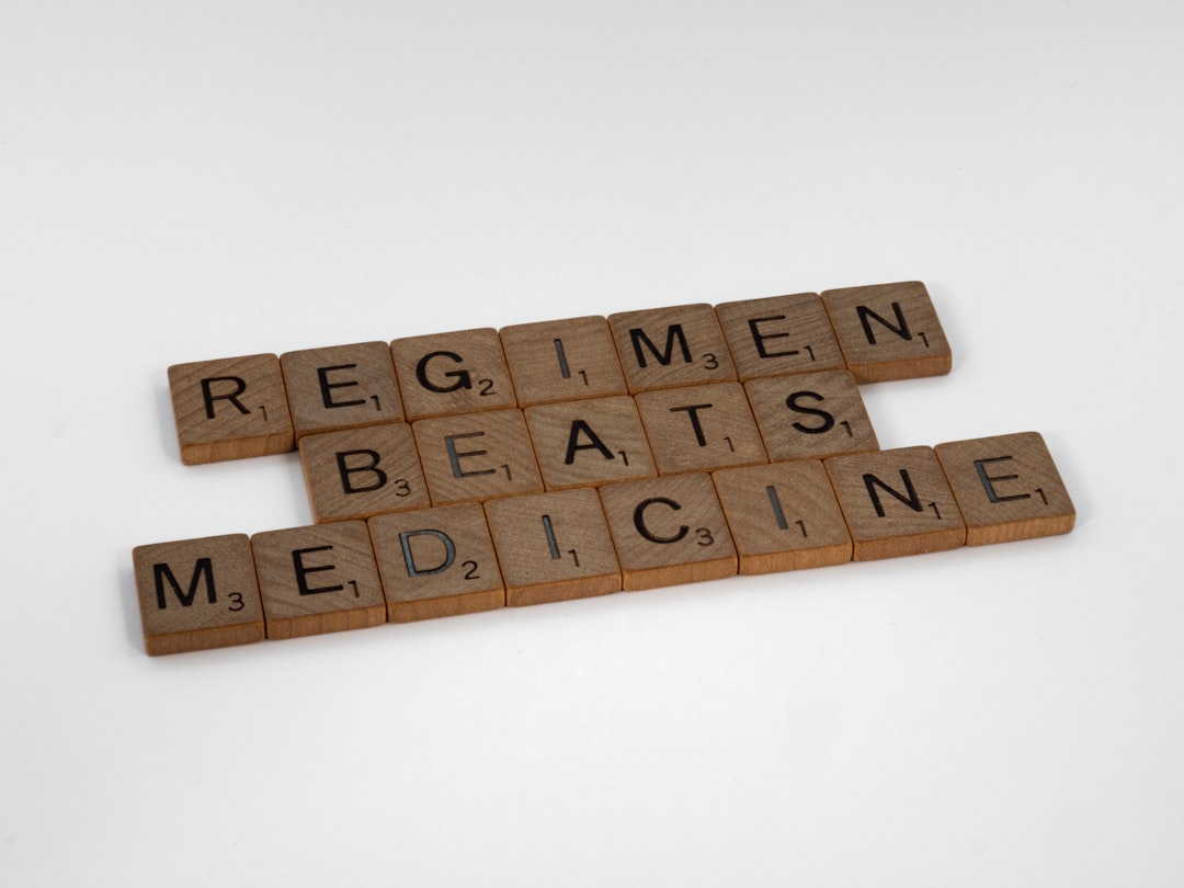 scrabble tiles spelling the word regimen beats medicine