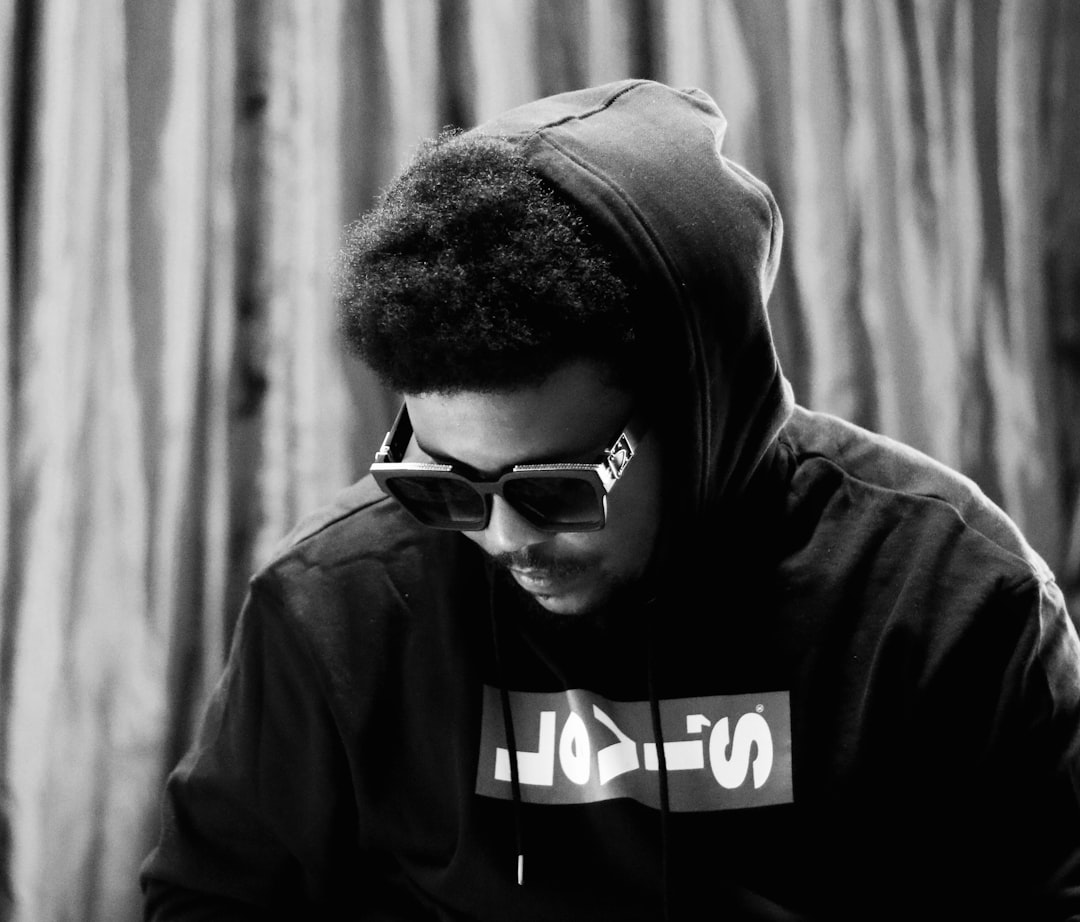 man in black hoodie wearing black framed eyeglasses