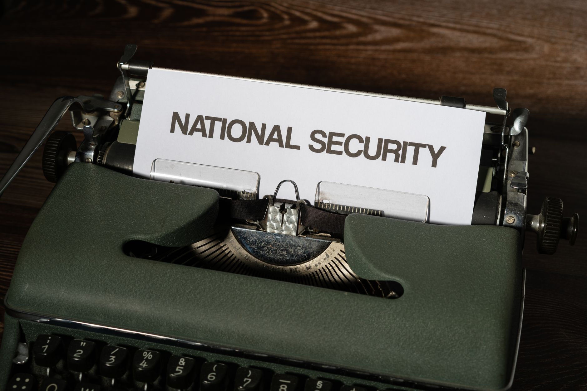 Close-up of a vintage typewriter with a paper showing the words 'National Security.'