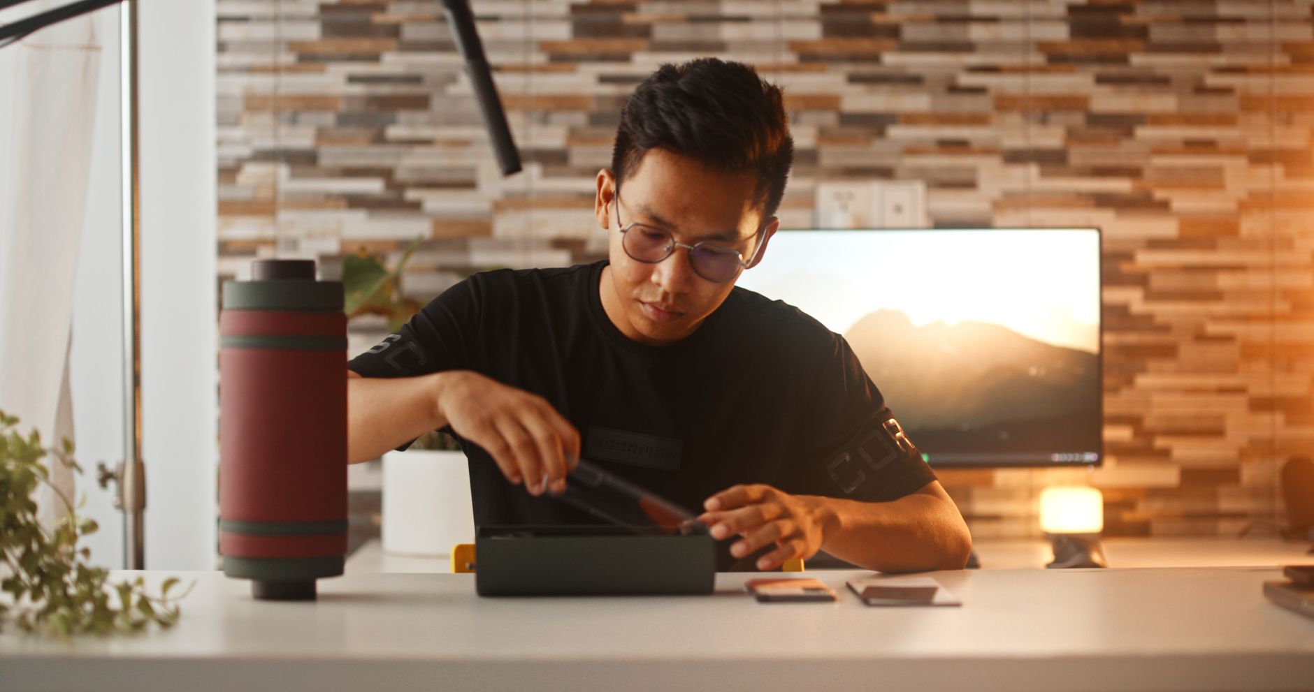 A young man unboxes a smartphone, showcasing modern technology in a cozy indoor setting.
