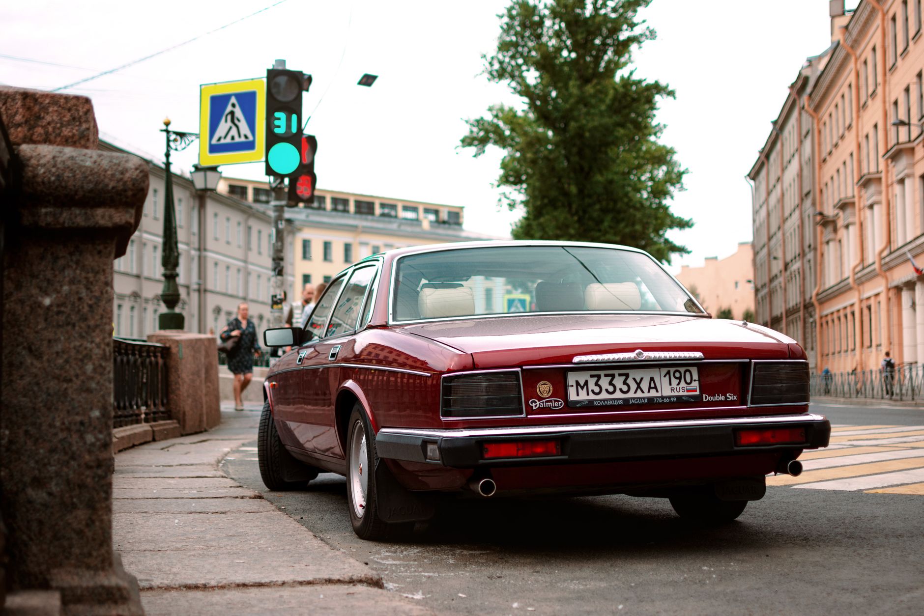 Classic vintage Daimler on a European city street with historic architecture.