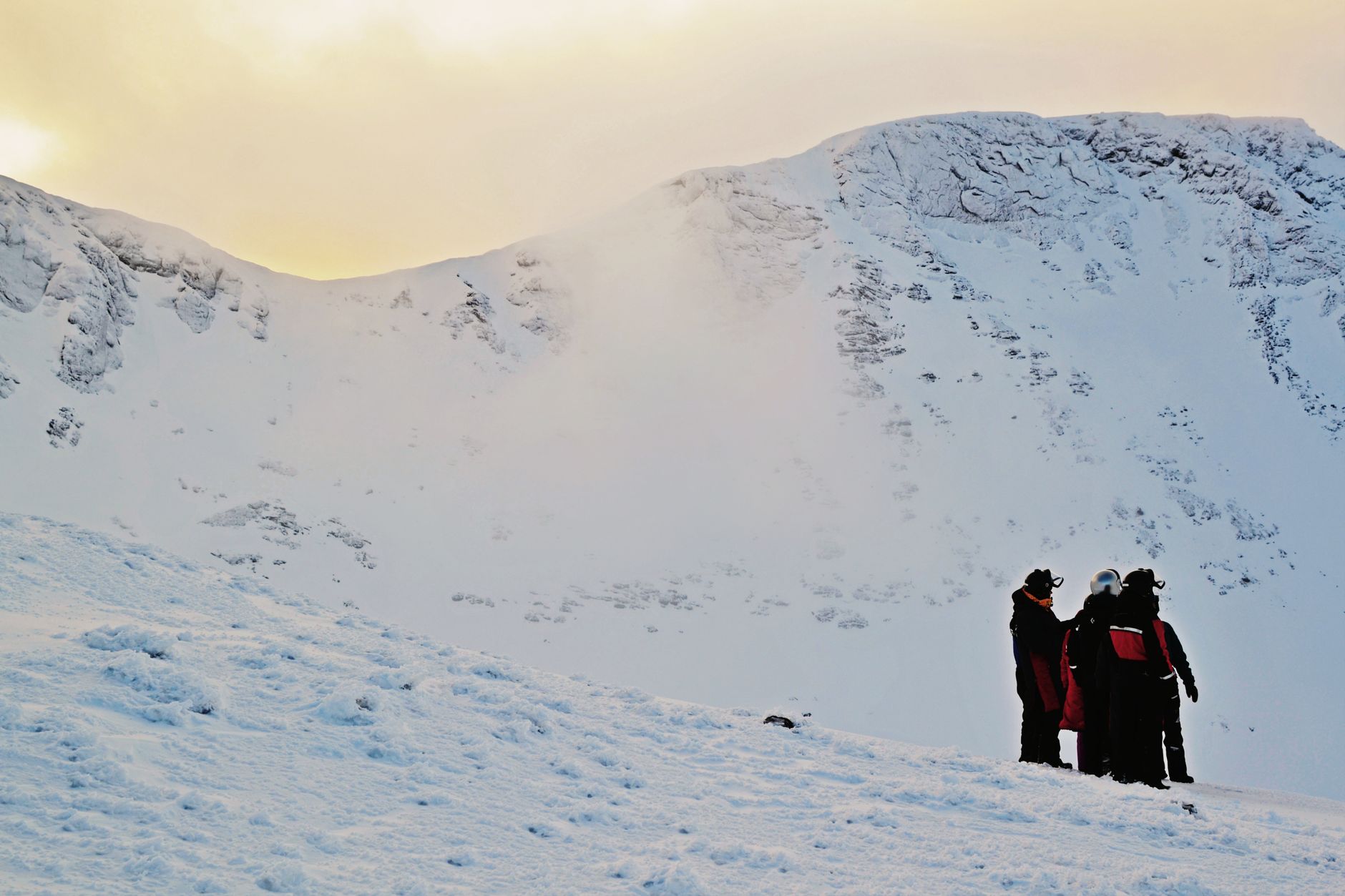 Hikers in winter gear exploring a snowy mountain under an overcast sky. Perfect for winter travel themes.