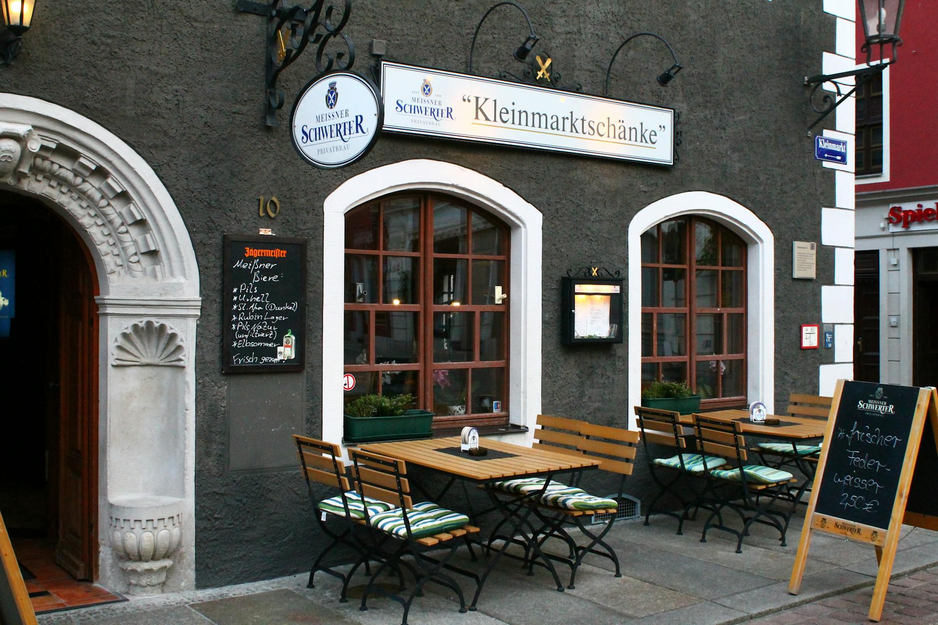 Quaint outdoor seating of Kleinmarktschänke in Meißen, Germany's Saxony region.