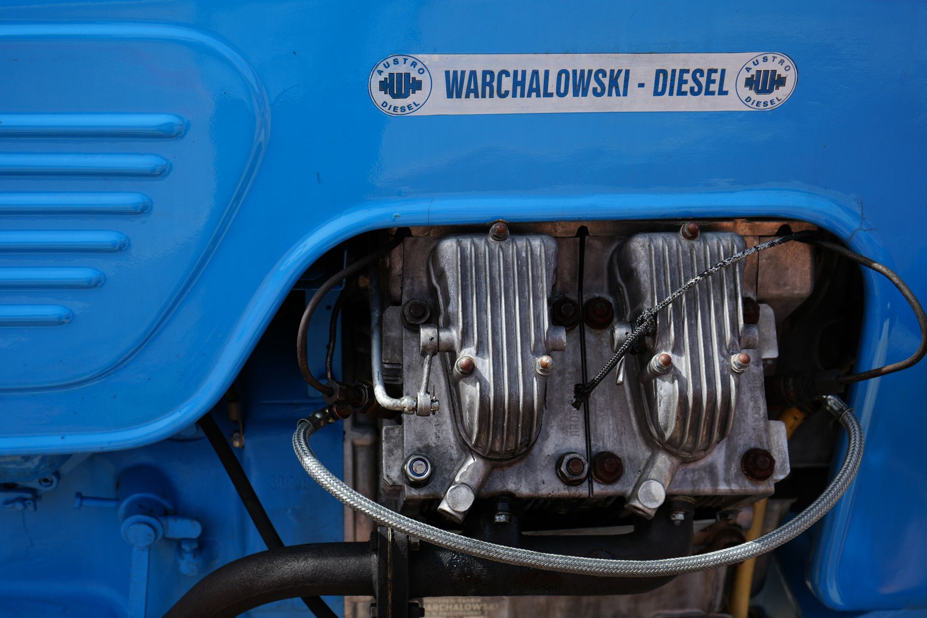 Detailed view of a Warchalowski diesel engine with visible components and vibrant blue cover.