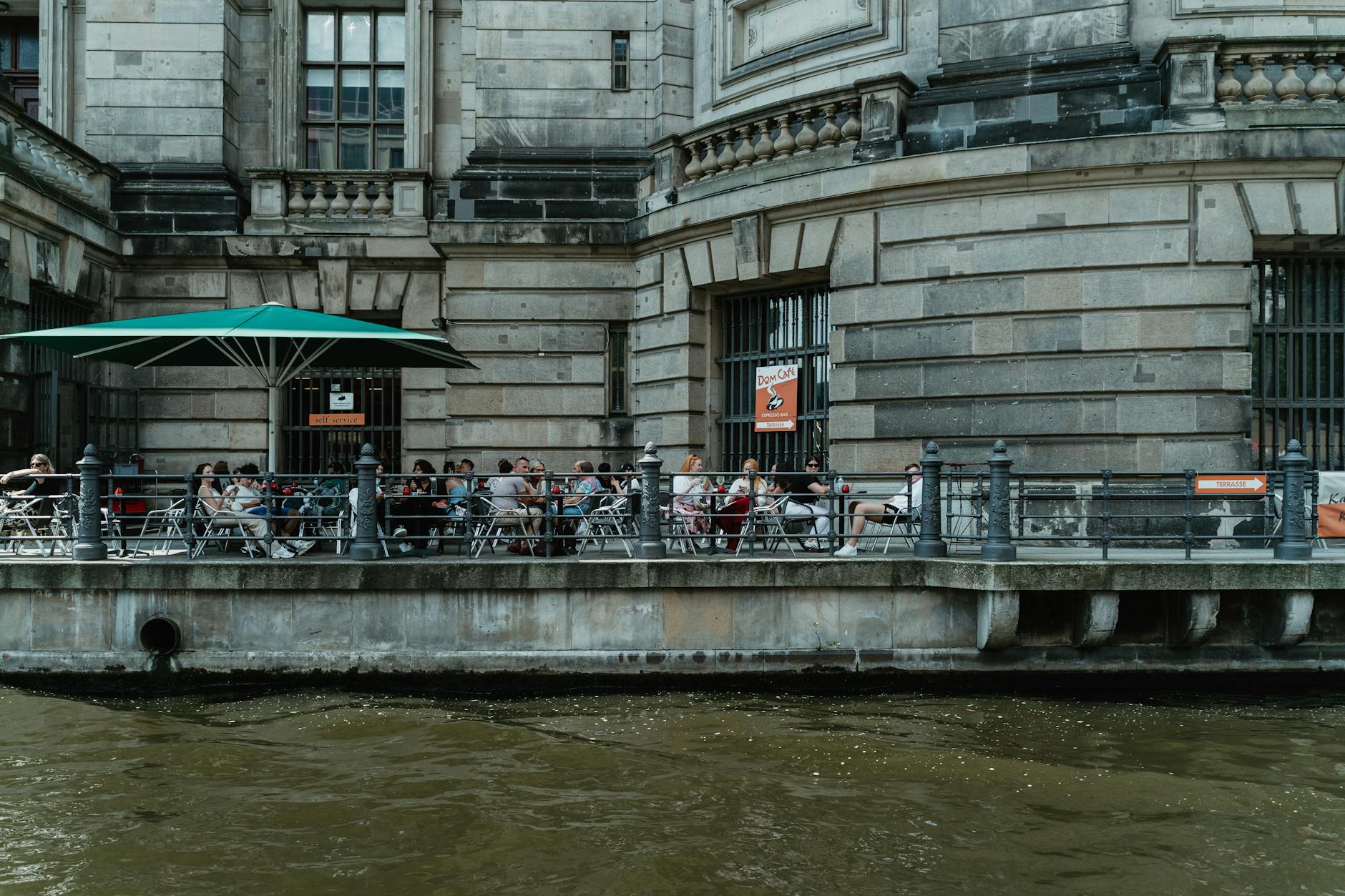 People enjoying time at an outdoor café by the Berliner Dome, Berlin, Germany.