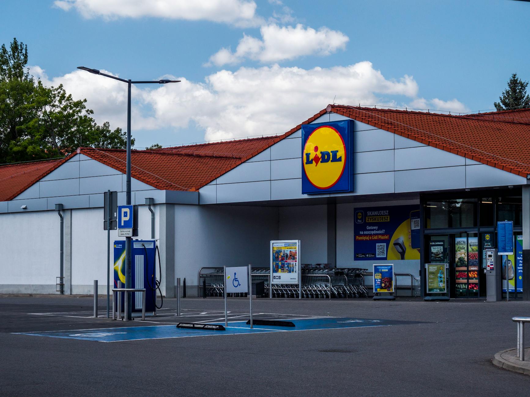 Lidl supermarket exterior featuring parking area and shopping carts on a sunny day.