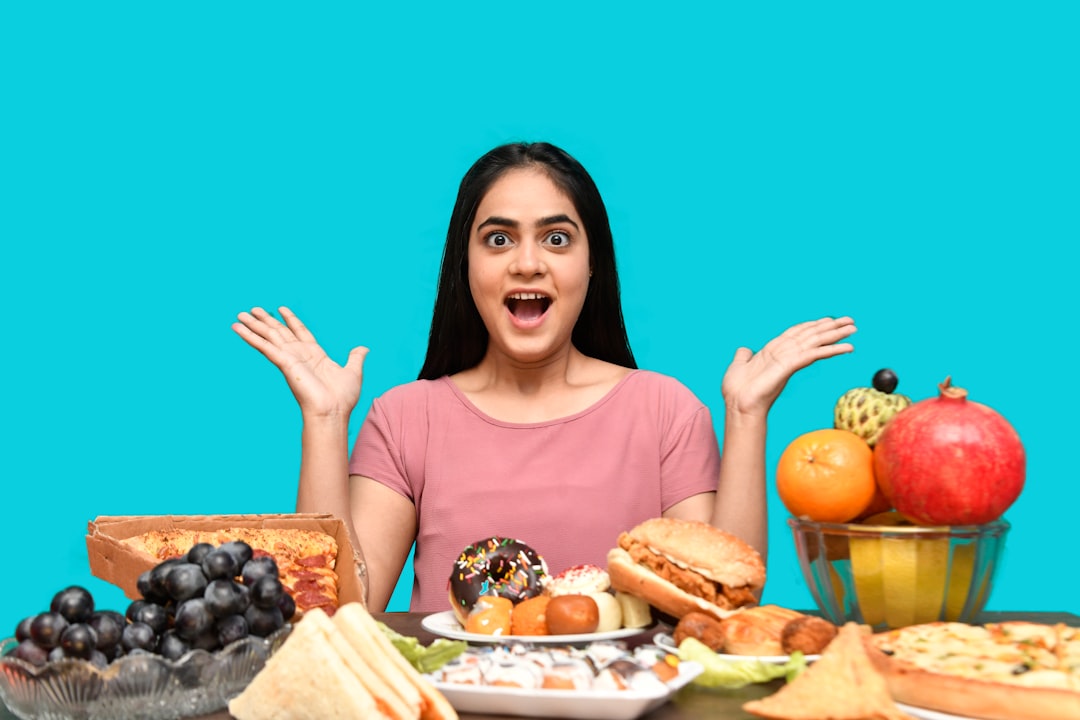 a woman with her mouth open and hands up in front of a table of food